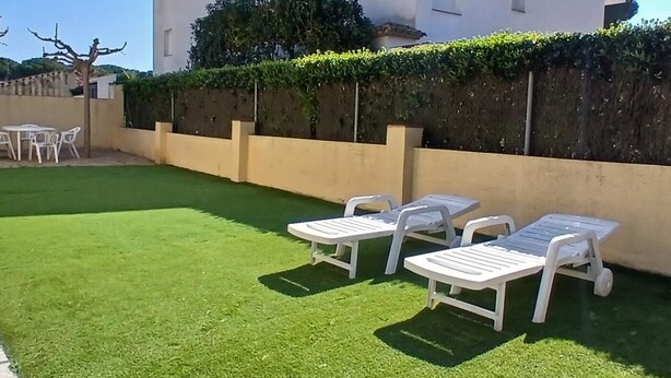 A building with a white exterior, a flat roof, and a hedge along the side. - Summer house close to the forest in L'Escala.HUTG-071512 (l'Escala)