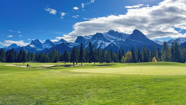 En golfbane med et bjergrigt baggrundsmotiv.