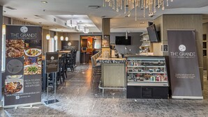 En restaurant med moderne interiør, inklusive et barområde, siddepladser og en lysekrone.