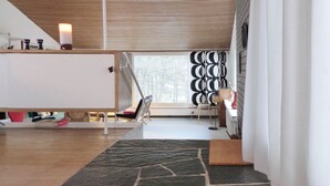 Een modern interieur met een trap, een bureau en een raam met jaloezieën.