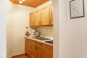Une cuisine avec des meubles en bois, un évier et une machine à café.