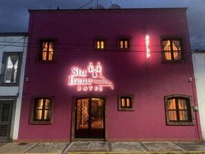 A building with a neon sign for 'Sta Irene Hotel'. - Hotel Santa Irene (San Pedro Cholula)