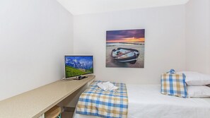Relax in a serene space with a single bed, desk, and scenic views on the flat-screen TV.