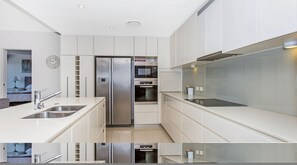 Features a double sink, stainless steel appliances, and a minimalist design.