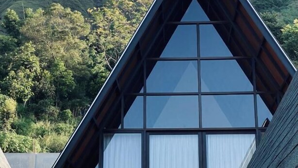 Um edifício moderno com telhado triangular e grandes janelas.