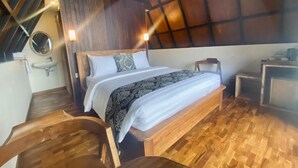 Quarto com cama de madeira, mesa de cabeceira pequena e uma cadeira.