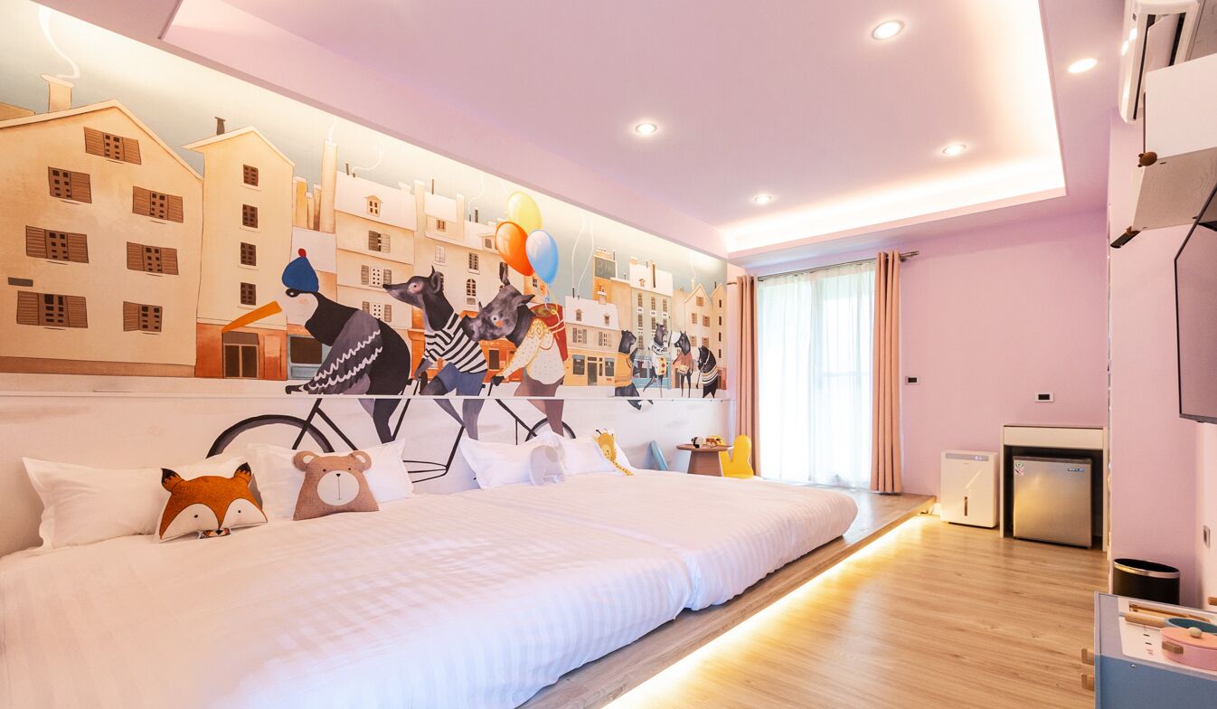 Una habitación de hotel moderna con una cama grande, un mural en la pared y una pequeña kitchenette.