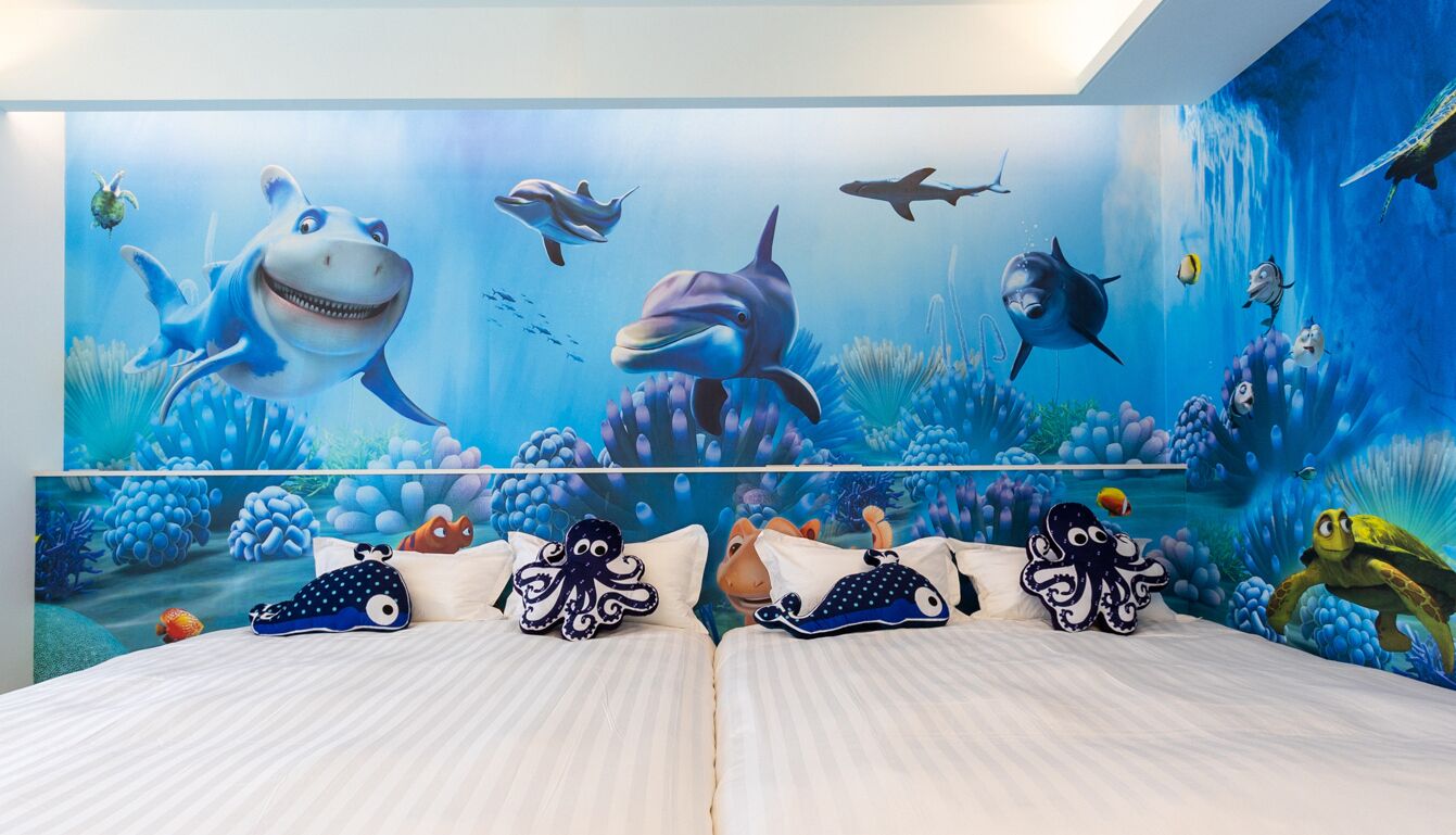 A bedroom with a mural of an underwater scene, including various sea creatures and a shipwreck.