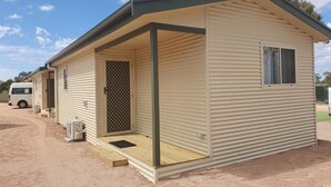 A single-story mobile home with a covered porch, a sliding door, and a small window. - Paringa Caravan Park (Paringa)