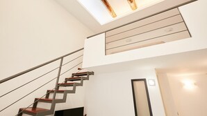 A modern staircase with a minimalist design, a glass ceiling, and a clean, white interior. - Studio Duplex at National Museum (Naples)
