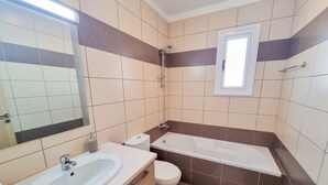 Ein Badezimmer mit Waschbecken, Toilette und Badewanne.