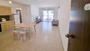 Eine moderne Wohnung mit Küche, Essbereich und einem Balkon.