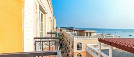 A balcony with a view of a beach and buildings.