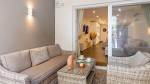 A modern living room with a sofa, a coffee table with a salt lamp, and a glass door leading to a dining area. - Modern Beautiful Pool And Sea Apt Qawra (St. Paul's Bay)