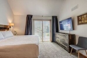 A hotel room with a bed, a television, a dresser, and a chair. - Grace-Jo @ Tamarack Highland 5 (Wisconsin Dells)