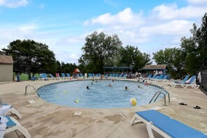 En swimmingpool med flere baner, omgivet af liggestole og parasoller.