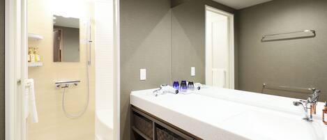 A modern bathroom with a double sink, a shower, and a large mirror.