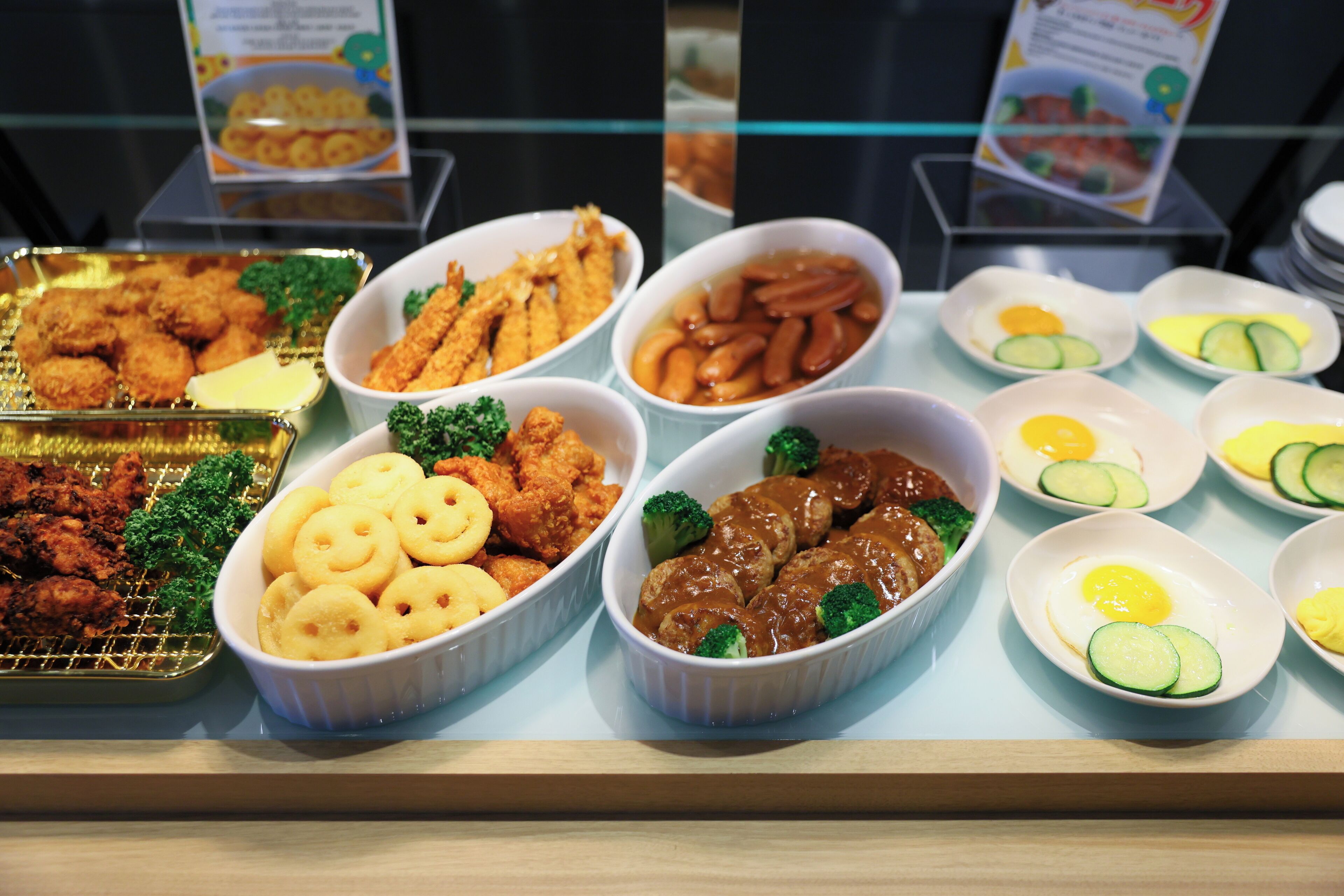 Un buffet proposant une variété de plats, notamment des plats frits, des légumes et de la viande.
