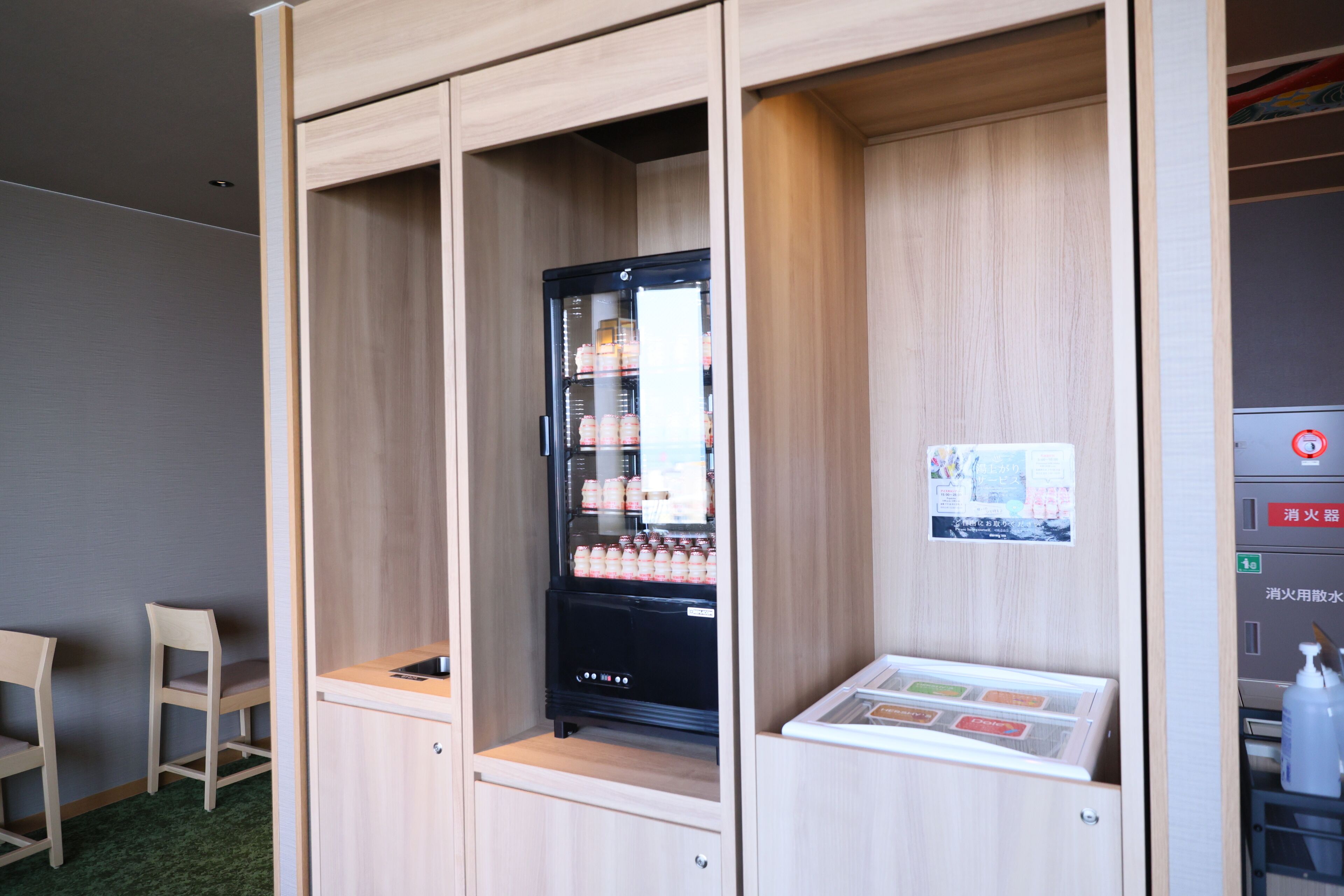 A compact kitchenette with a refrigerator, a small sink, and a microwave.