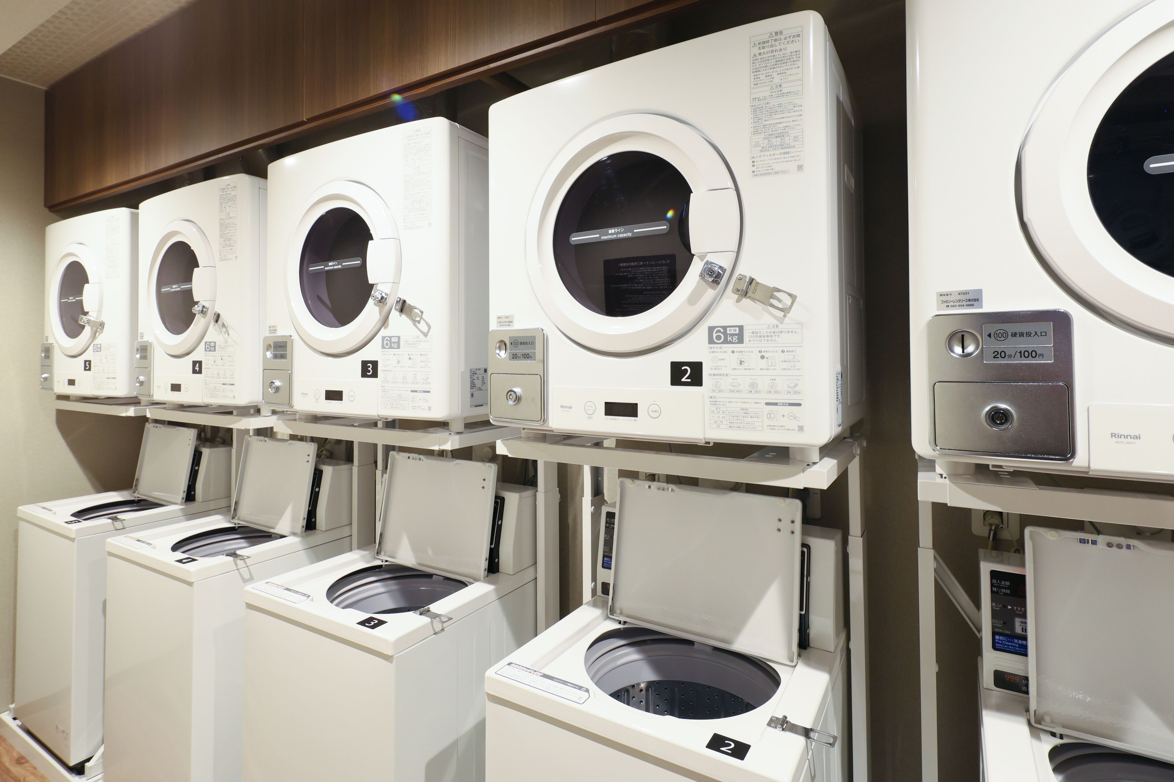 A row of front-loading washing machines in a commercial setting.