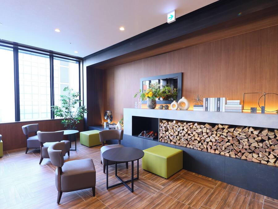 A modern lobby with a wooden wall, a fireplace, and a large window.