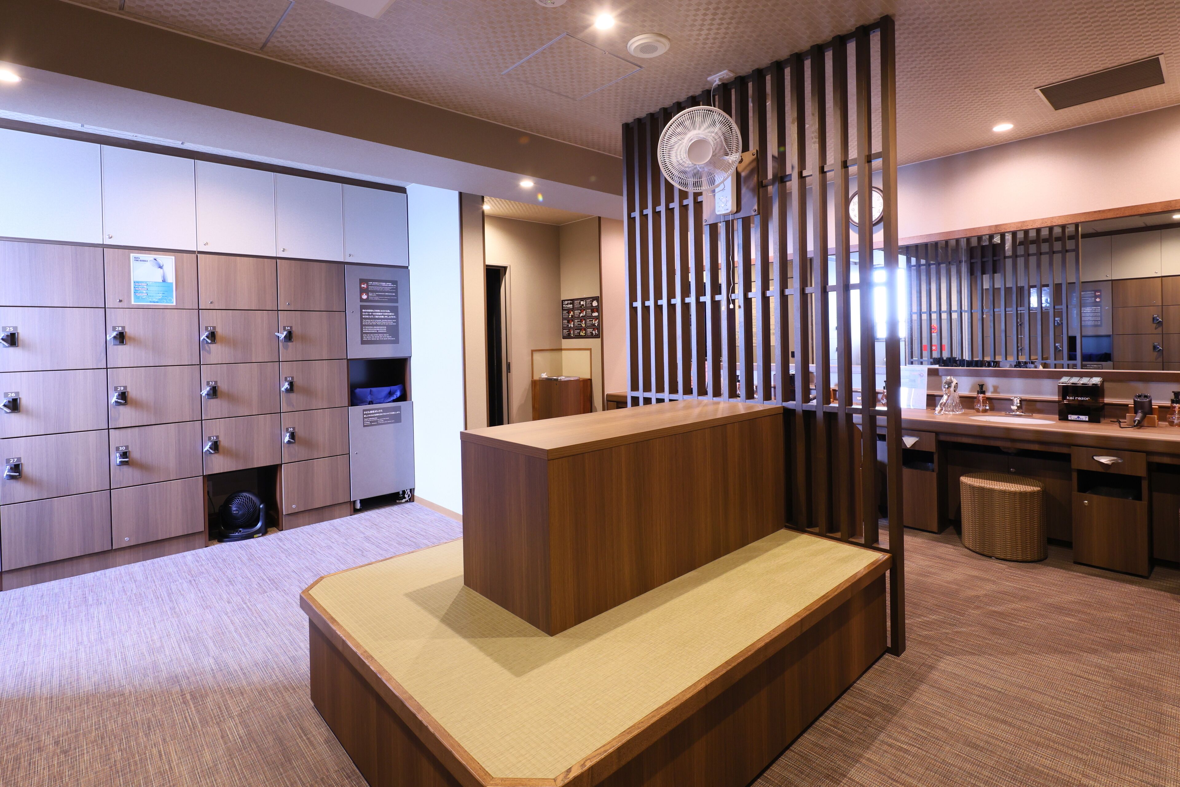 A hotel lobby with a reception desk, lockers, and a seating area.