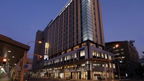 Ein mehrstöckiges Hotel mit modernem Design, das eine markante Eingangspartei und eine große Glasfassade aufweist.