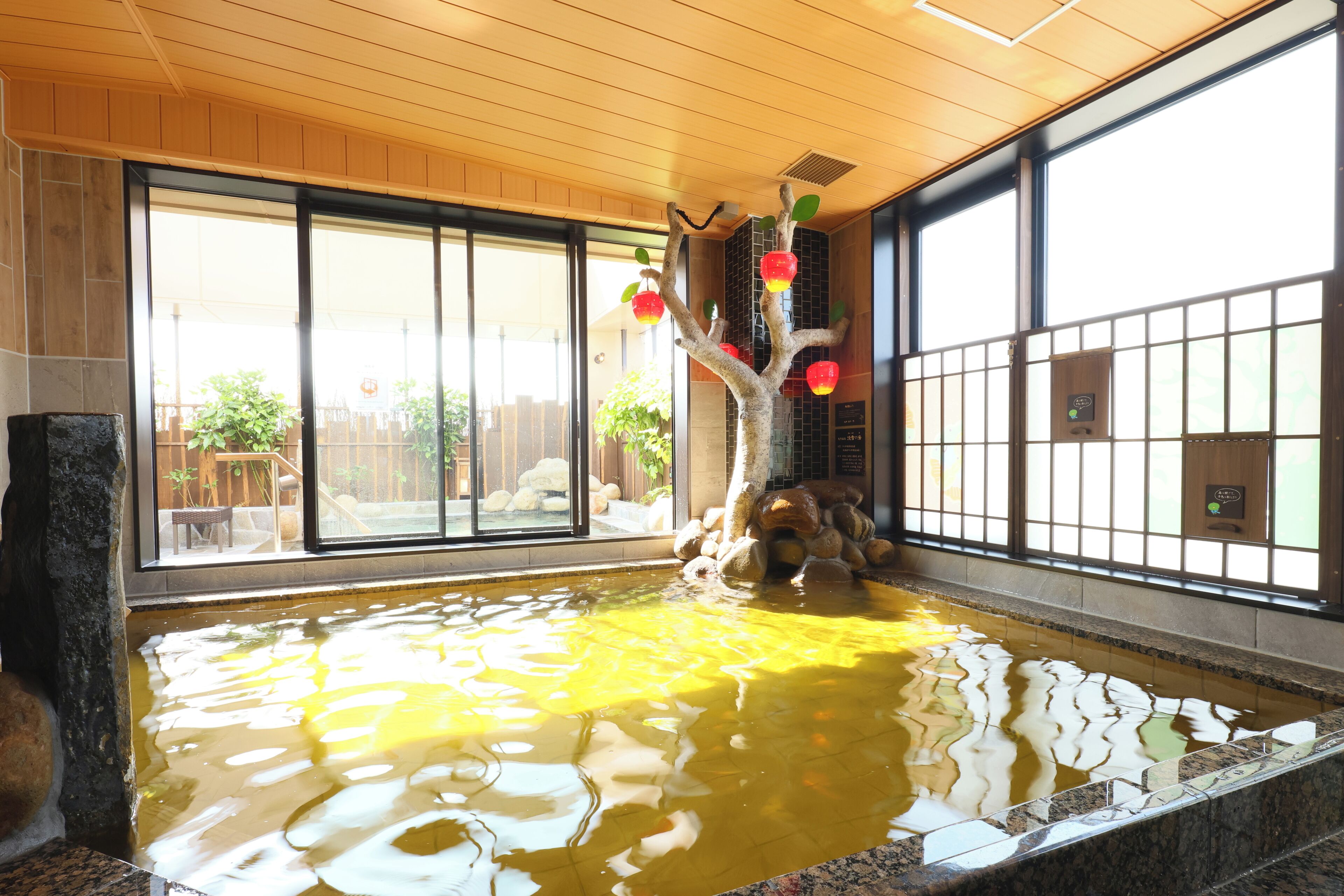 Una tranquila fuente interior con un árbol decorativo y rocas.