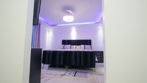 Ein Schlafzimmer mit Bett, Kommode und Deckenleuchte.