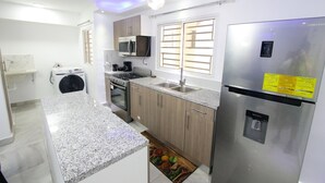 Eine moderne Küche mit Granit Arbeitsplatten, Edelstahlgeräten und Holzschränken.