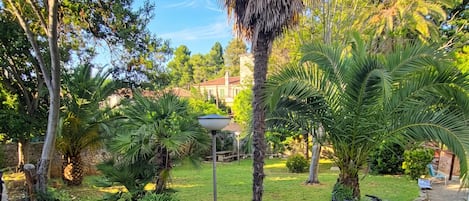 A garden with various trees, a lamp post, and bicycles.