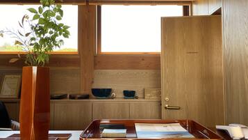 Un mostrador de recepción de madera con una planta, una bandeja con documentos y una puerta que dice “STAFF ROOM”.