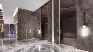 A modern lobby with marble flooring, elevators, and ambient lighting. - Shenzhen Naive S Hotel (Xili Metro Station Store) (Shenzhen)