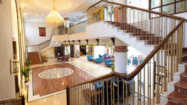 A spacious lobby with a marble floor, a grand staircase, and a chandelier. - MAHARAJA AGRASEN PALACE - PURE VEGETARIAN (Mawal)