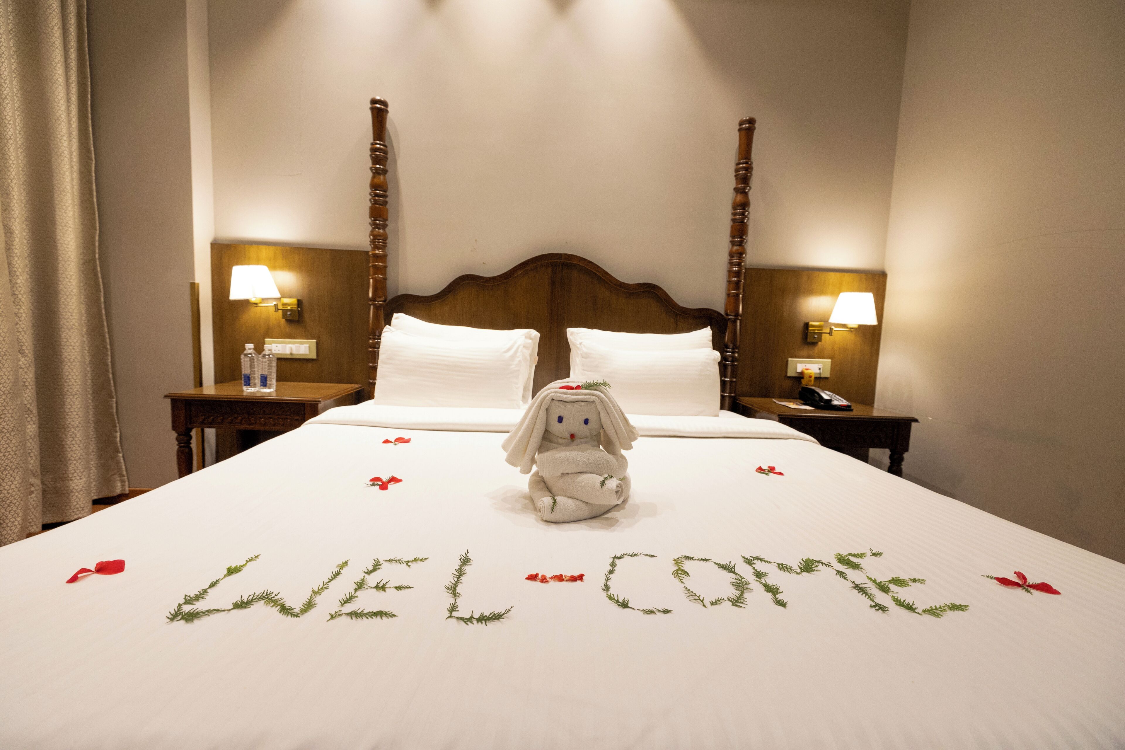 Una habitación de hotel con una cama, un felpudo y un peluche decorativo.