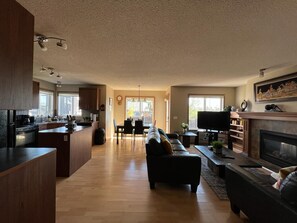 A spacious living area with a kitchen, dining area, and a fireplace.