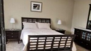Une chambre à coucher avec un lit, une commode et une table de chevet.