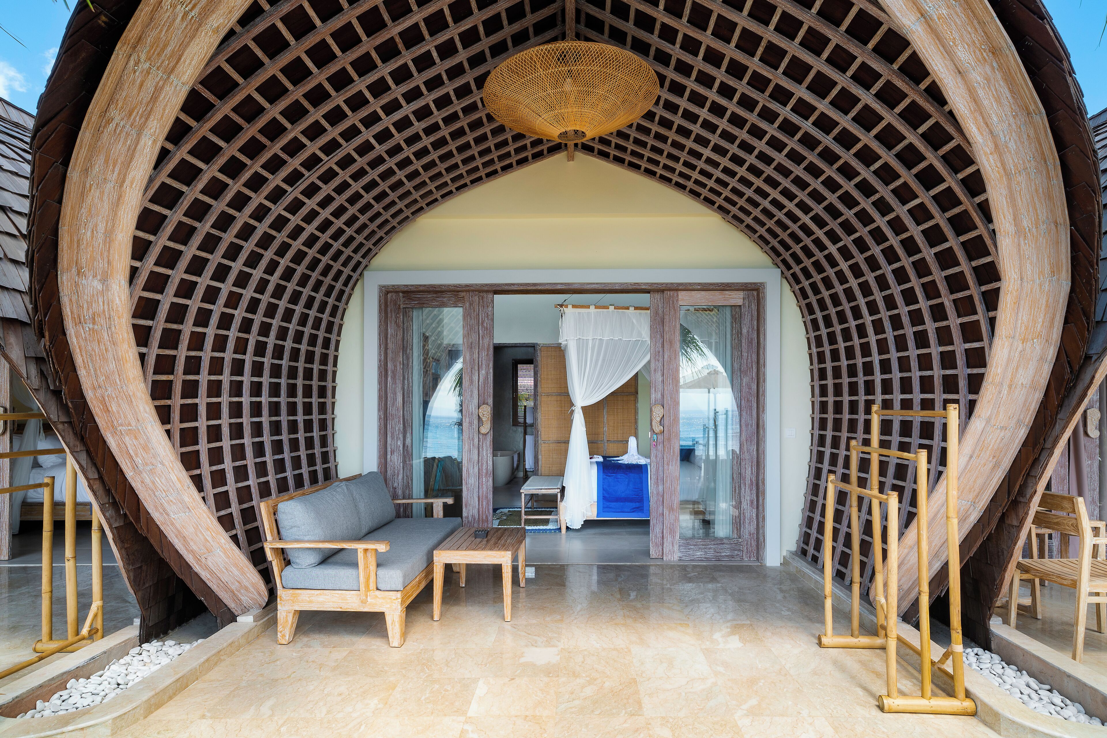 Ein Zimmer mit gewölbter Holzbalkendecke, einer Couch, einem Tisch und einem Bett mit Baldachin.