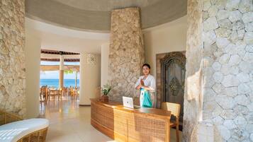 Welcome to our oceanfront reception area, where guests can check in and enjoy stunning views of the ocean through large windows.