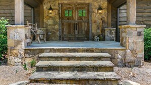 A stone porch with a wooden door, stone steps, and two lanterns. - Nearly Six Private Acres. A Spring-Fed Trout Pond. Shortoff MountainViews | Shortoff Mountain View (Highlands)