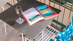 A table with a book and a glass of water on it. - Nooria Sicilian Charme Rooms (Cefalù)