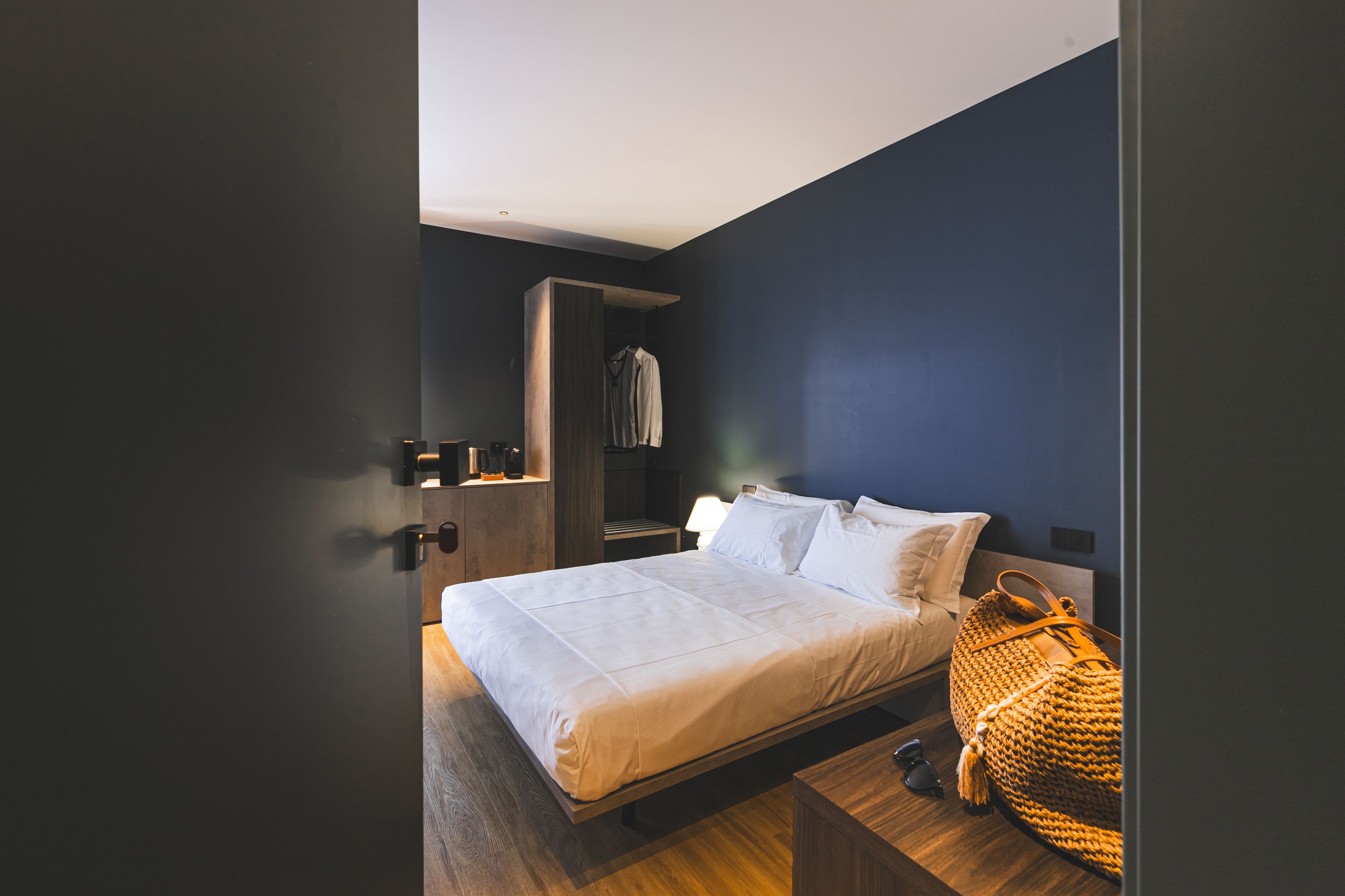 Une chambre à coucher moderne avec un lit, une table de chevet et une armoire.