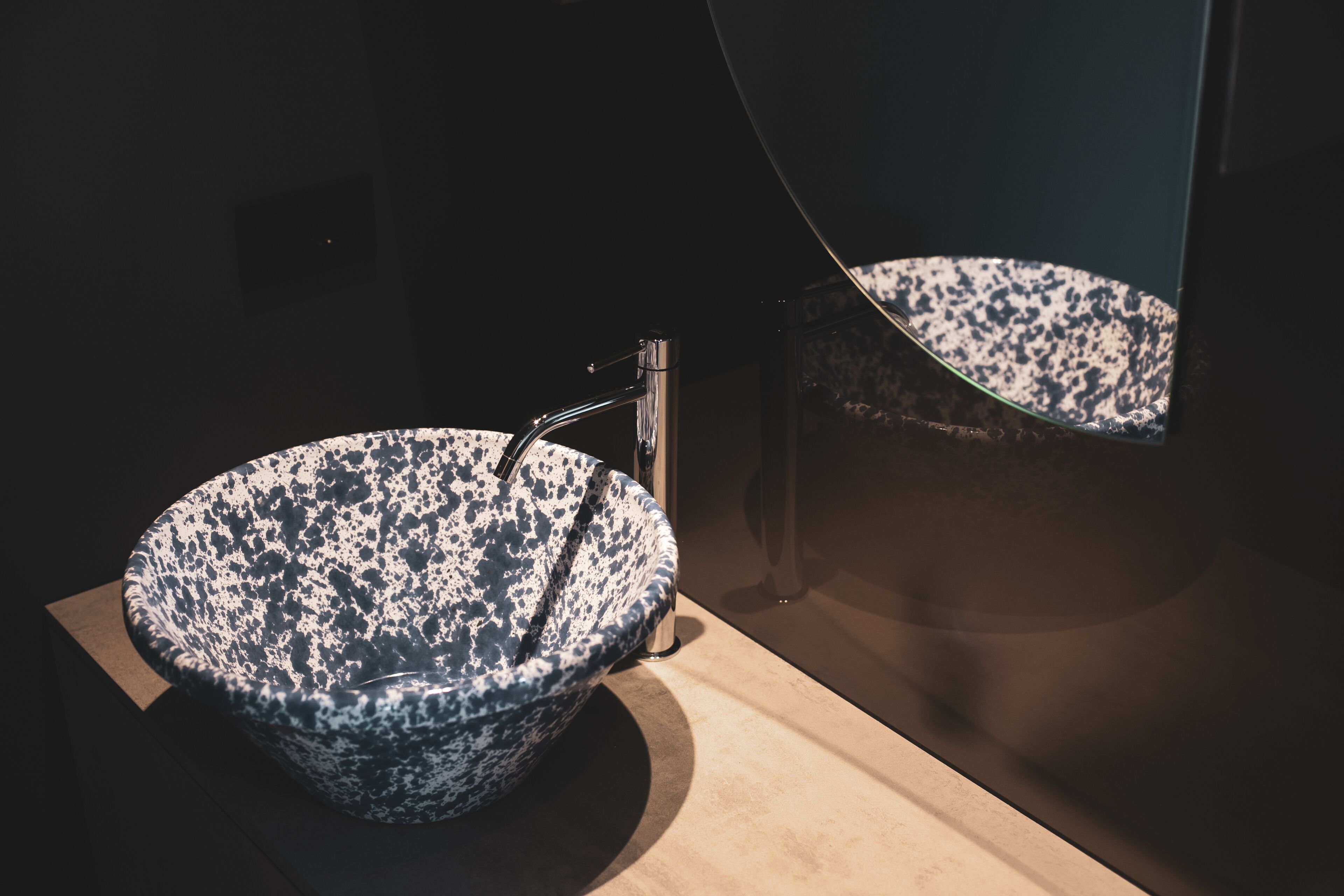 Un bagno moderno con un lavandino grande e strutturato e uno specchio.