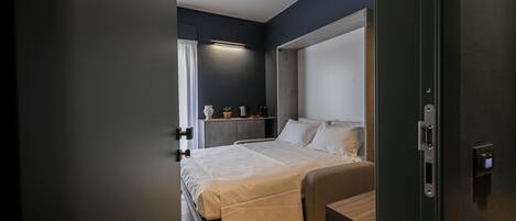A modern bedroom with a bed, bedside table, and a nightstand.
