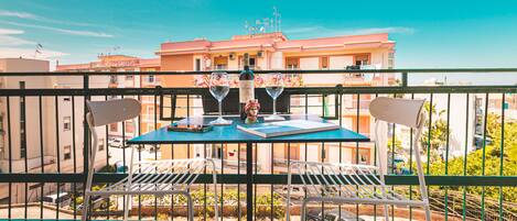 A balcony with a table and chairs, a bottle of wine, and a menu.