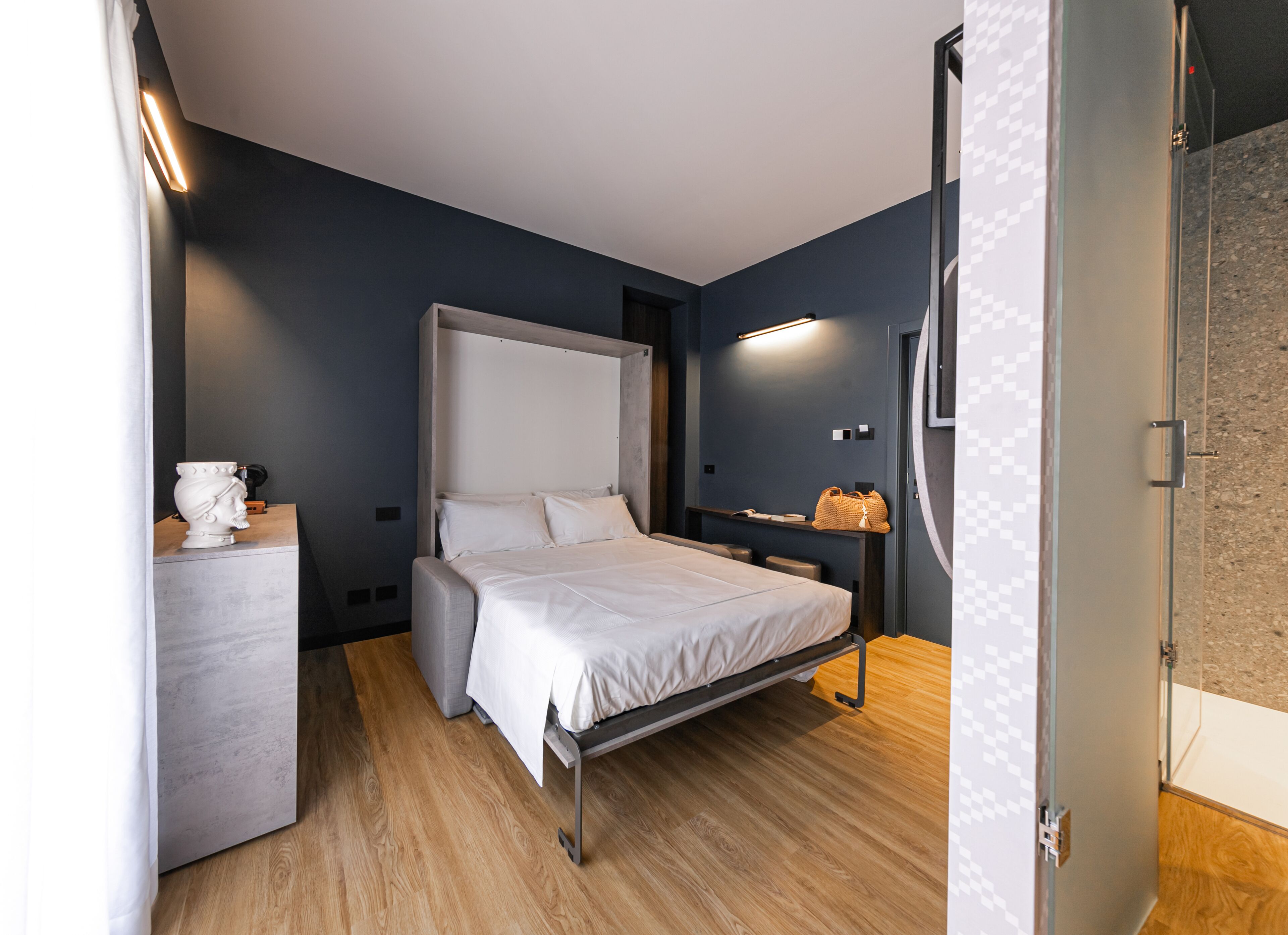 A modern bedroom with a bed, bedside table, and a nightstand.