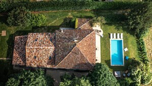 An aerial view of a house with a tiled roof, a swimming pool, and surrounding greenery. - L'Hacienda Occitane- Heated pool- air conditioning (Nègrepelisse)