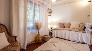 A cozy bedroom with a bed, a chair, a window with curtains, a chandelier, and a vase with pampas grass. - L'Hacienda Occitane- Heated pool- air conditioning (Nègrepelisse)