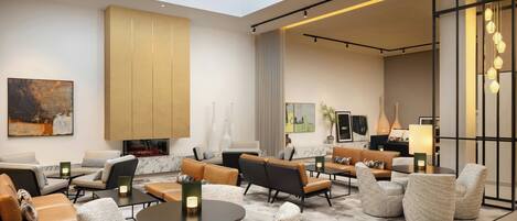 Eine moderne Hotelhalle mit hoher Decke, Oberlichtern und verschiedenen Sitzbereichen, darunter Sofas und Sessel.