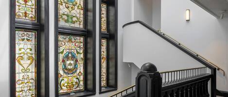 A staircase with black balusters and a handrail, leading to an upper floor.